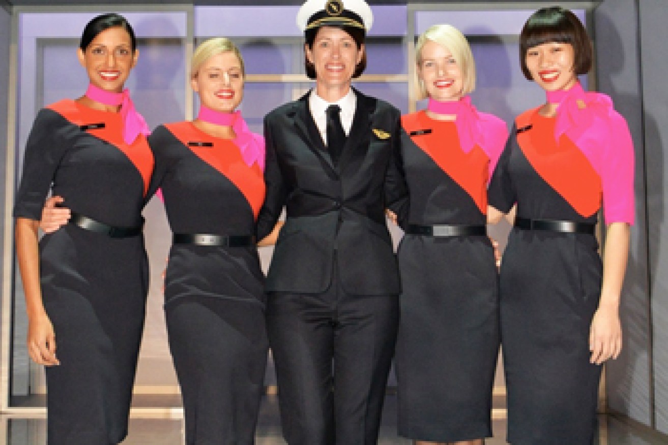 An actual Qantas pilot in the new uniform, flanked by attendants. Photo: AAP