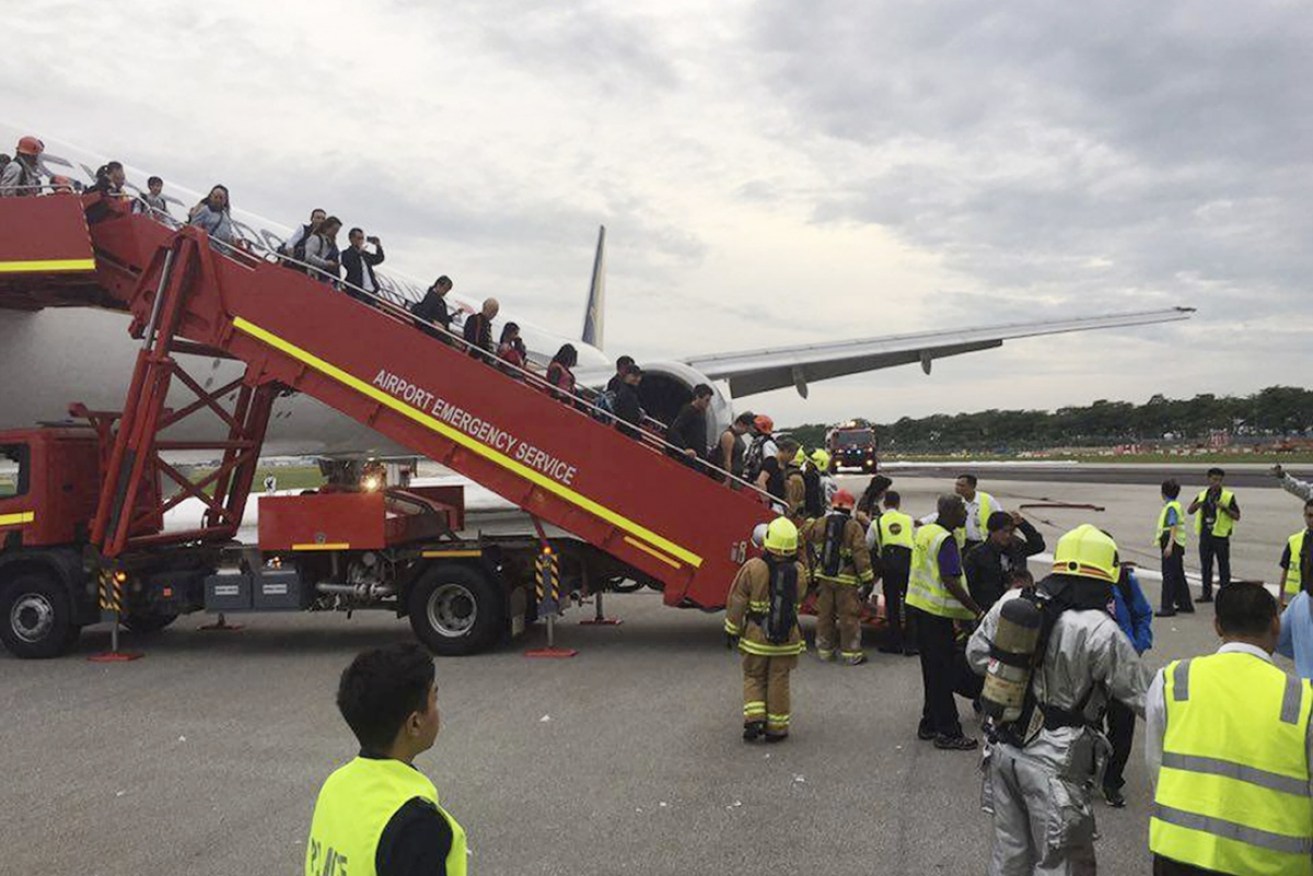 Passengers disembark after the fire. Photo: AAP.