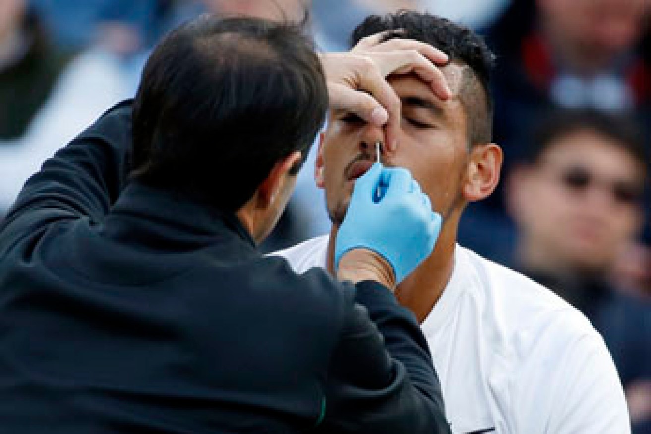 Nick Kyrgios of Australia receives medical attention during his men's singles match against Feliciano Lopez of Spain on day six of the Wimbledon Tennis Championships in London, Saturday, July 2, 2016. (AP Photo/Alastair Grant)