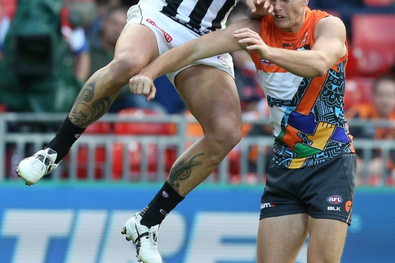 Jesse White of Collingwood and Adam Tomlinson of the Giants. Photo: AAP