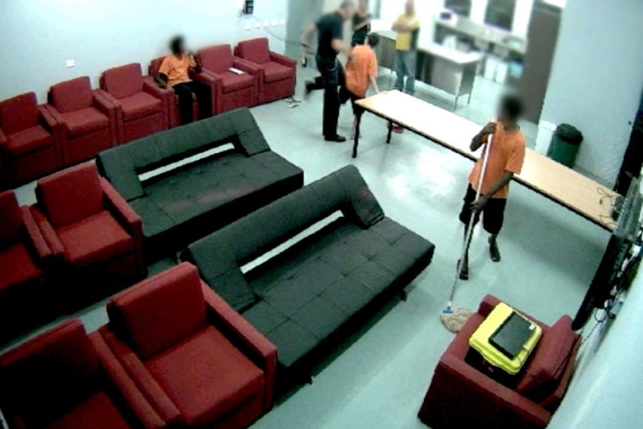 CCTV footage shows a prison guard knocking or kneeing a young boy in NT youth detention centre.