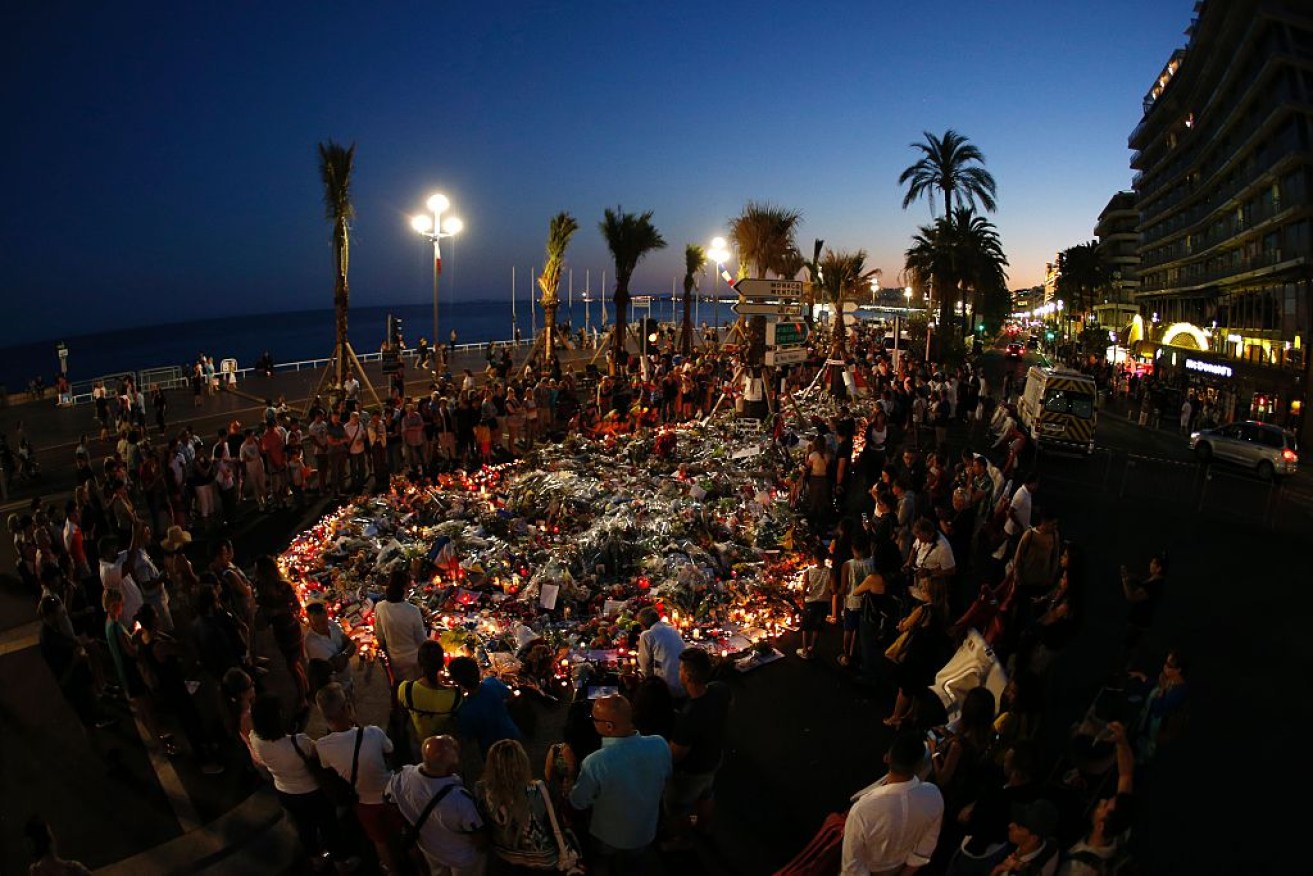 People gather at a makeshift memorial on the Promenade des Anglais in Nice. 