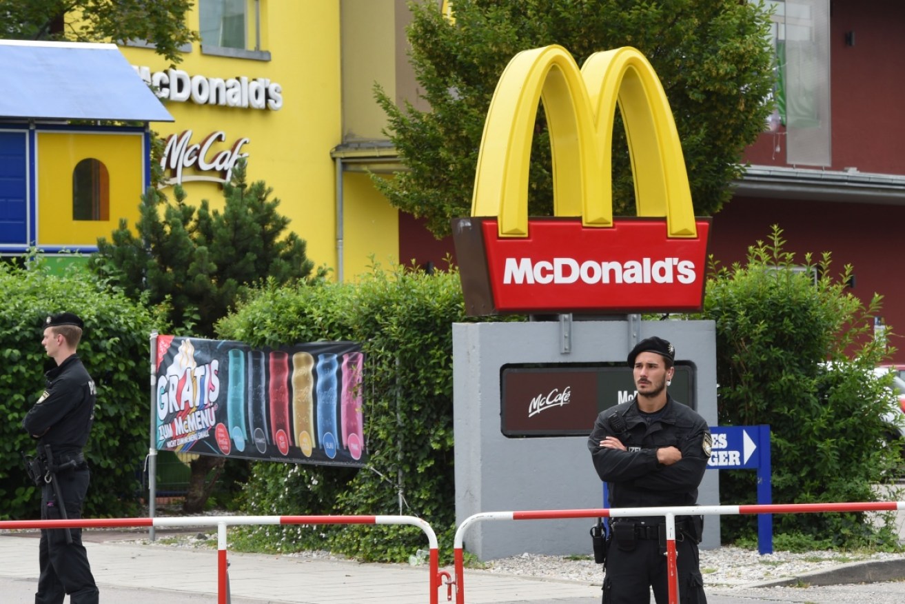 Policemen stand in front of a fast food restaurant where the shooting took place in Munich.