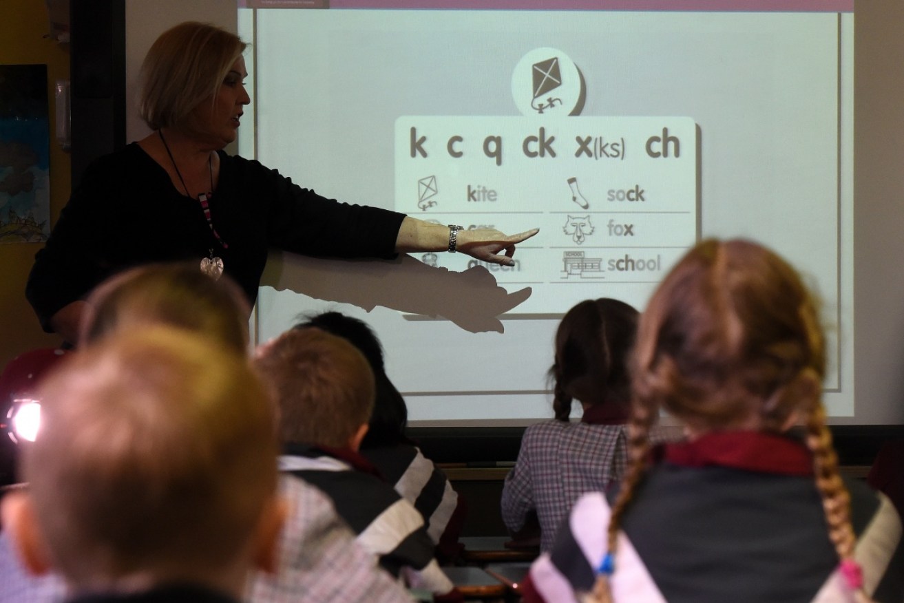 A teacher points at a board during a lesson at Stafford State School in Brisbane.