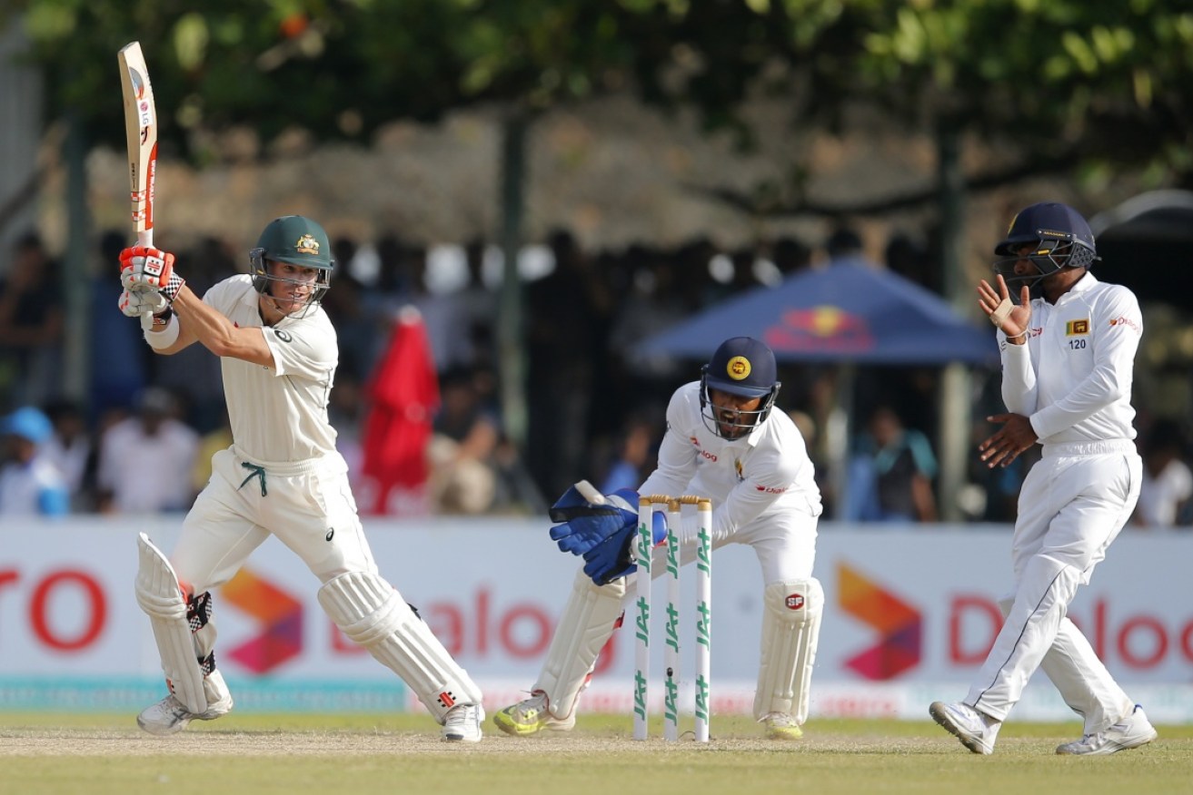 David Warner plays a shot as Sri Lankan wicketkeeper Dinesh Chandimal watches.