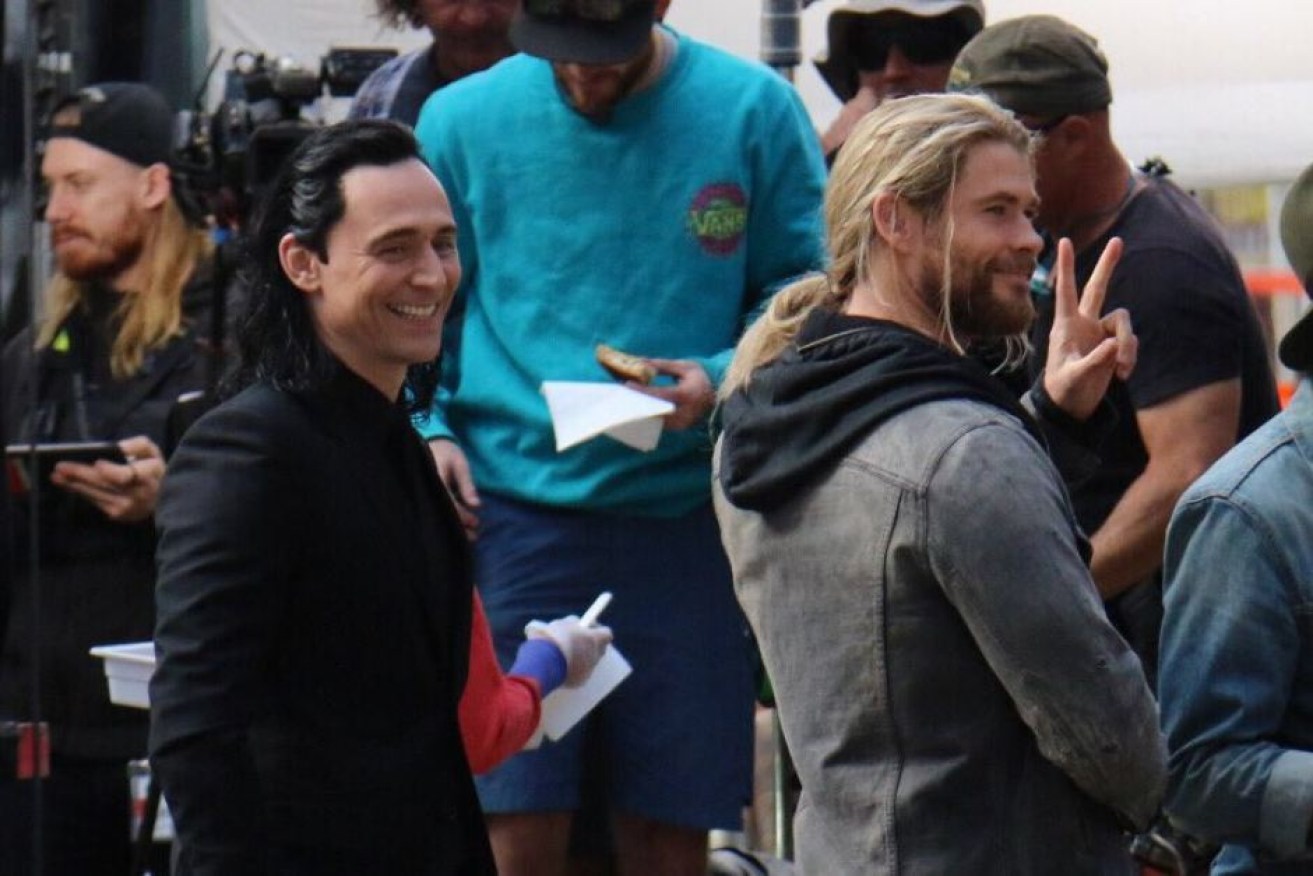 Tom Hiddleston and Chris Hemsworth smile at onlookers as they prepare to film Thor: Ragnarok in Brisbane. Photo: ABC