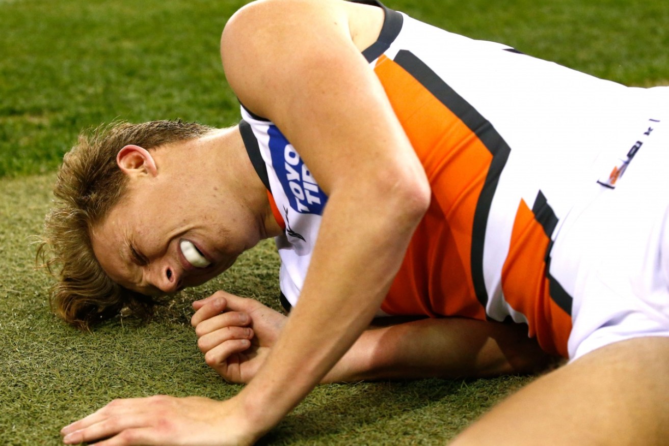 Lachie Whitfield pictured after knocking his head on the turf at a game in June. 
