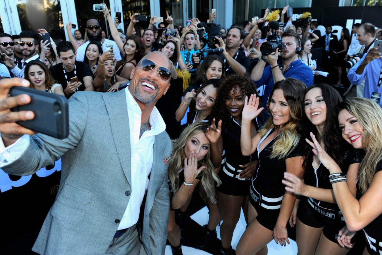Dwayne Johnson flashes his $64 million smile at a premier in Florida this year.