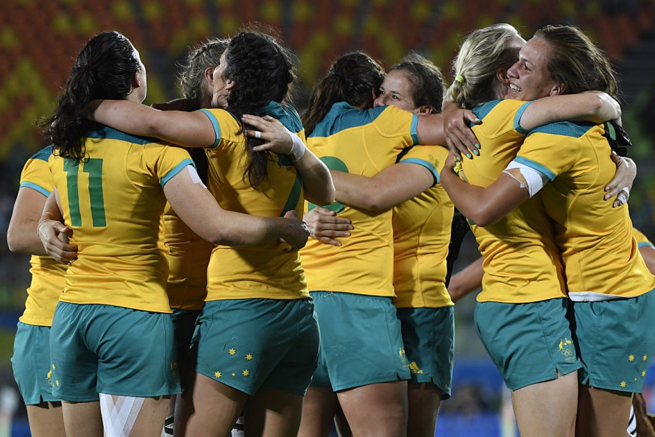 Australia's players celebrate victory in the womens rugby sevens gold medal match between New Zealand.