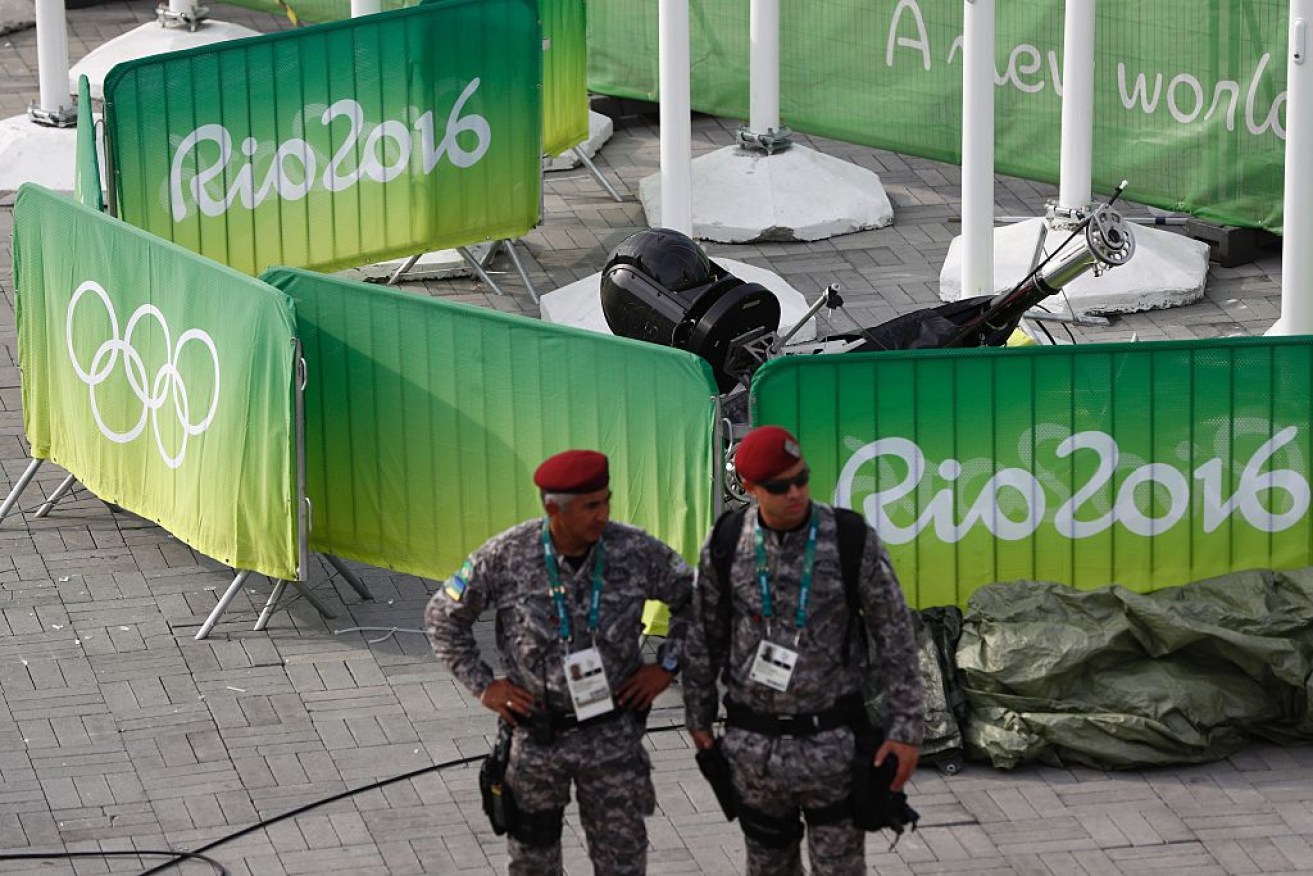 Guards stand by the fallen television camera at the Olympic park.