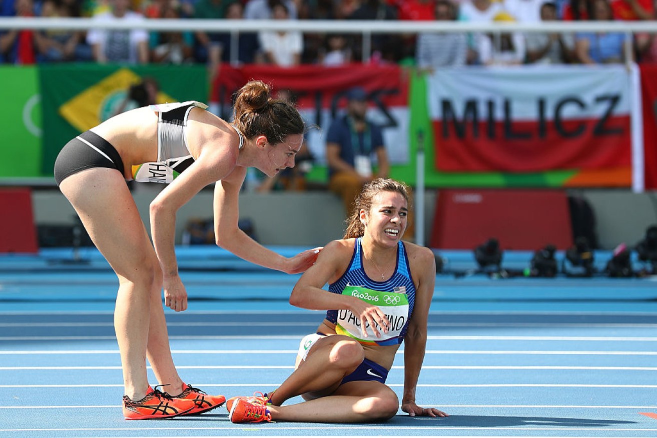 Abbey D'Agostino of the United States (R) is helped by Nikki Hamblin of New Zealand.