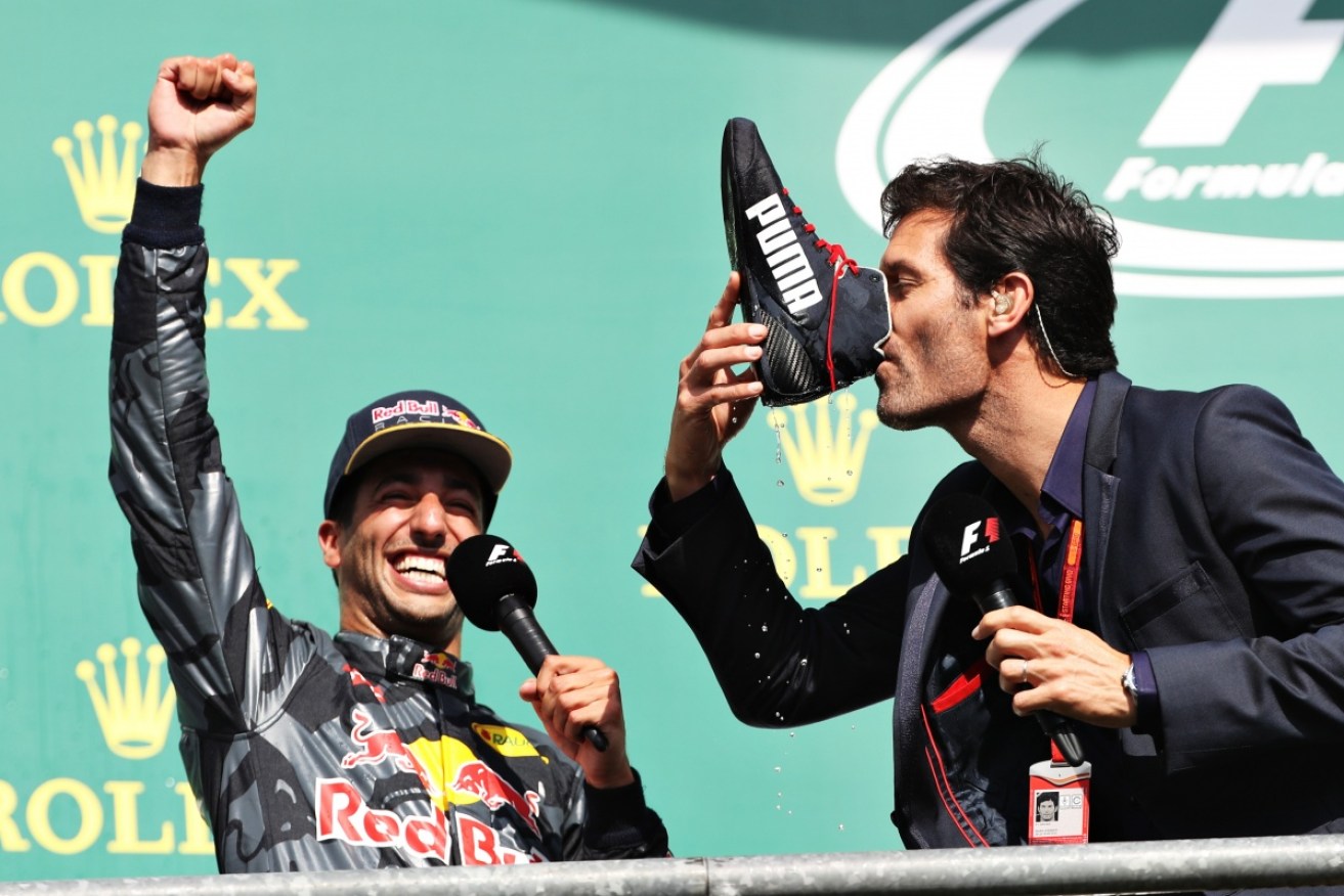 Mark Webber drinks champagne from Daniel Ricciardo's boot on the Belgium Grand Prix F1 podium.