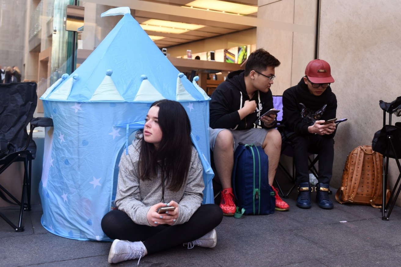 Customers queue outside the Apple Store in Sydney. 