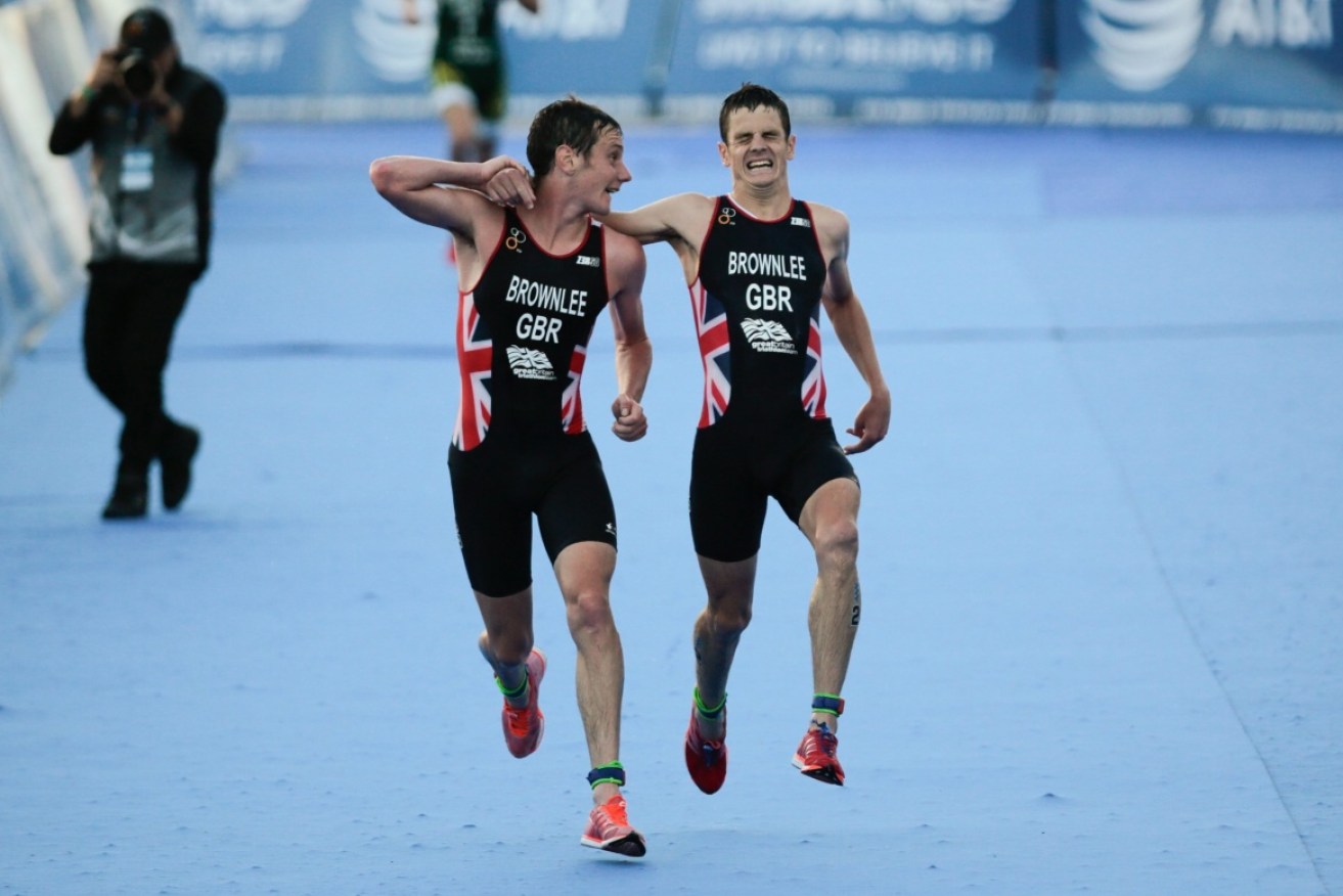 Alistair Brownlee (L) helps his brother Jonathan reach the finish line.