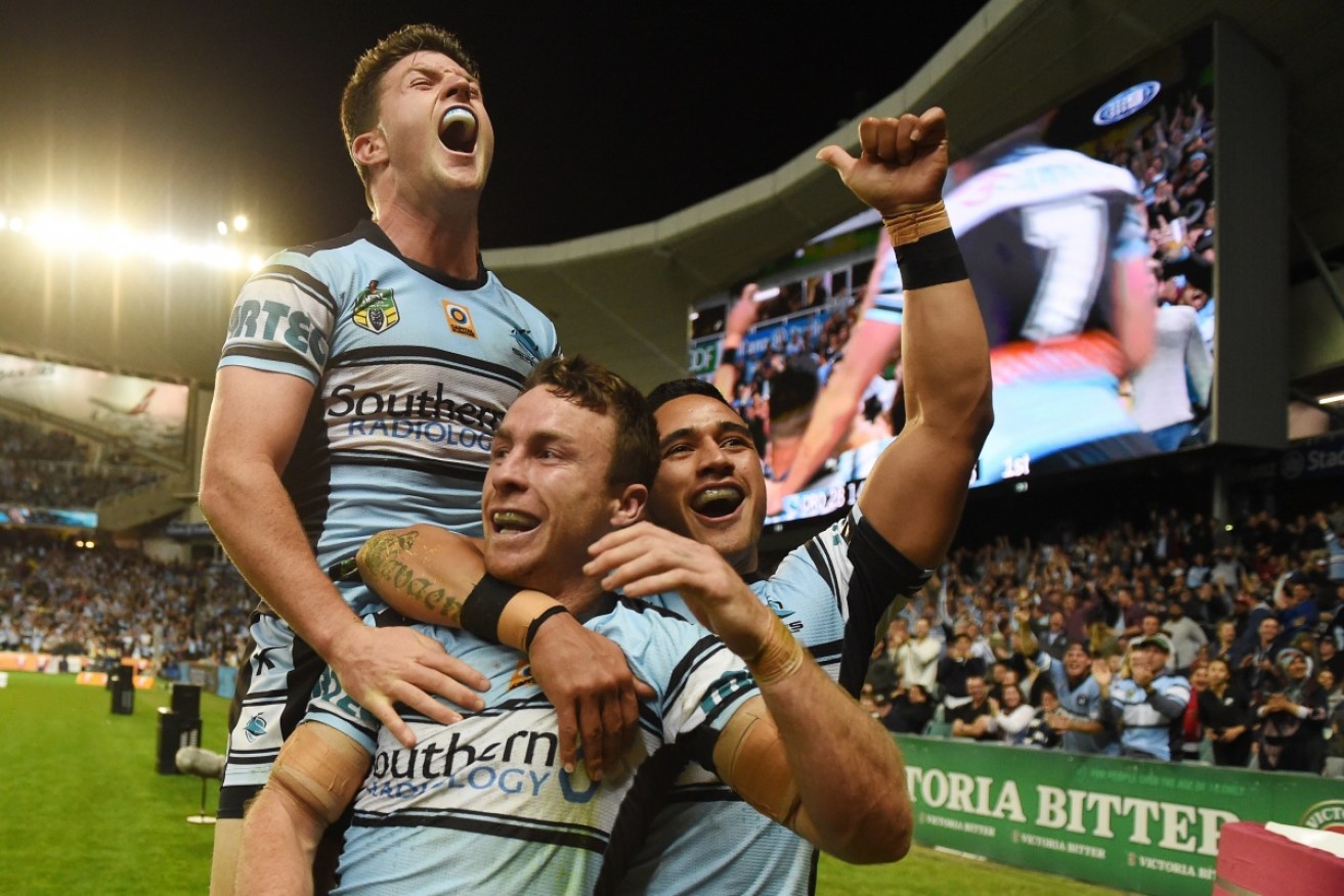 Cronulla's James Maloney celebrates his run-away try with Chad Townsend and Valentine Holmes during the NRL preliminary final against North Queensland 