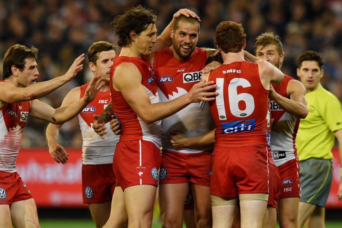 Sydney Swans teammates swamp Buddy Franklin after a goal against Geelong in the preliminary finalat the MCG.