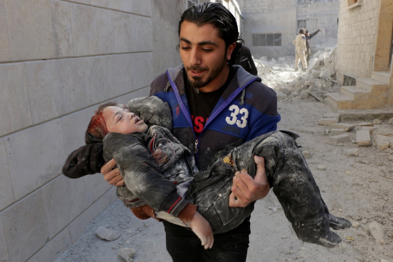 A wounded Syrian child is carried to help after Russian airstrikes targeted residential areas in Aleppo.