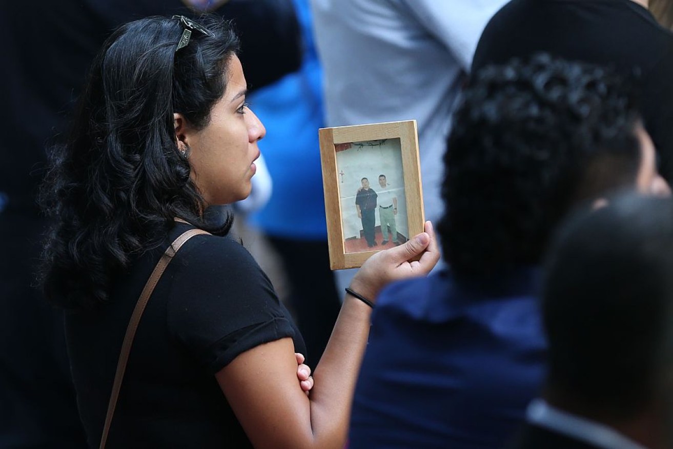 A woman carries a photo of o 9/11 attacks victim on the 15th anniversary of the 9/11 in Ground Zero, New York.