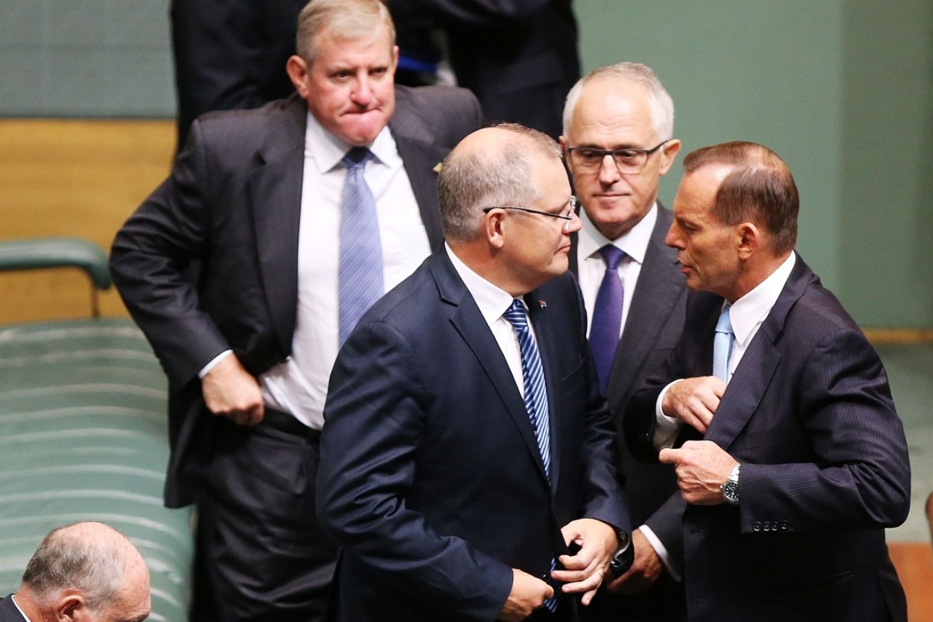 Treasurer Scott Scott Morrison talks with Tony Abbott, watched by  Malcolm Turnbull.