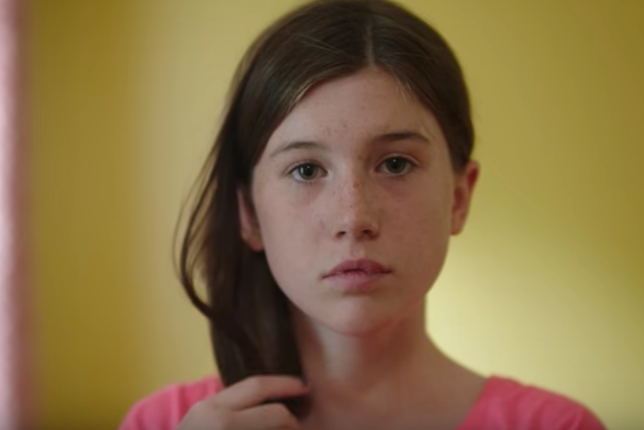 A young girl listens to offensive Trump comments in the ad. 