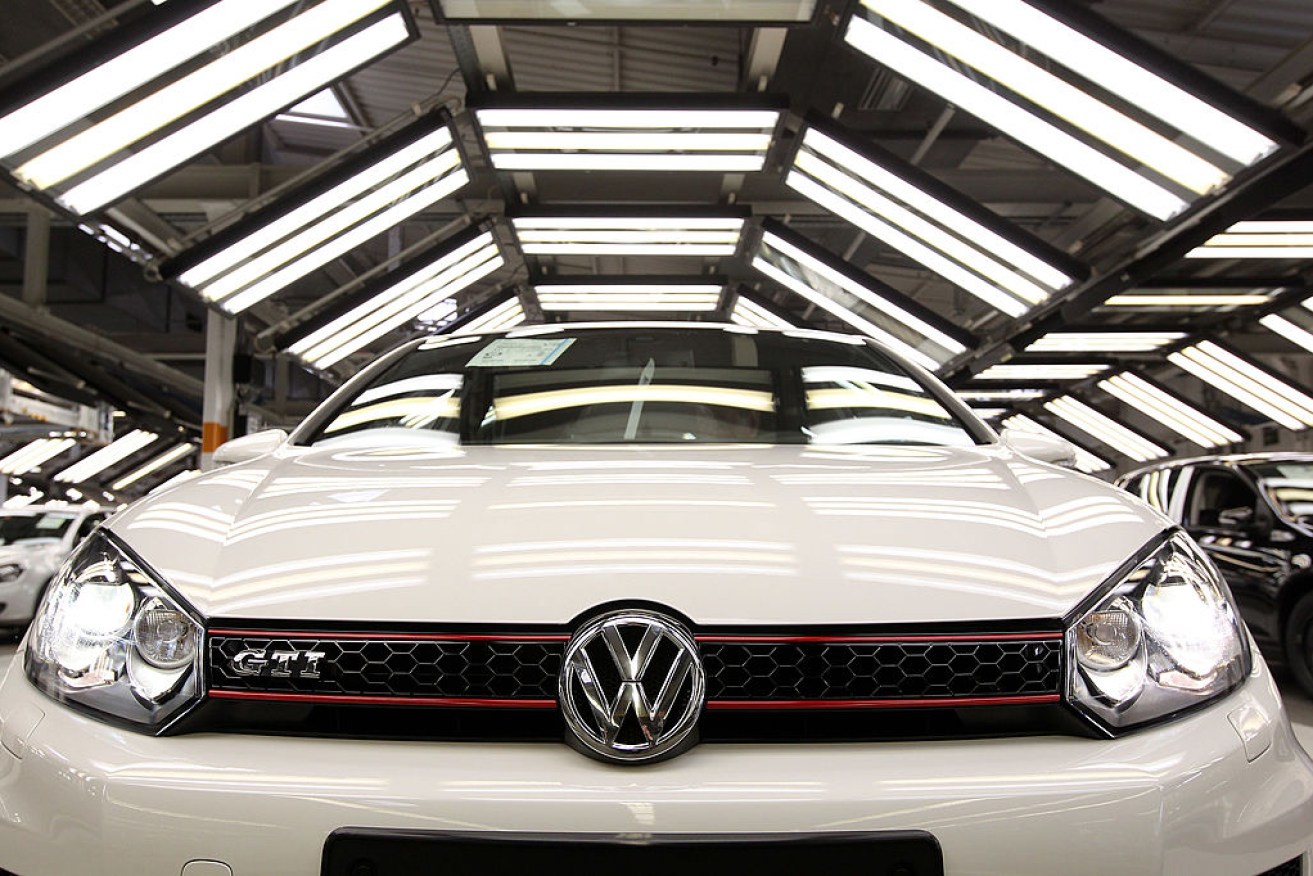 A finished Volkswagen Golf GTI prepares to drive off the assembly line.
