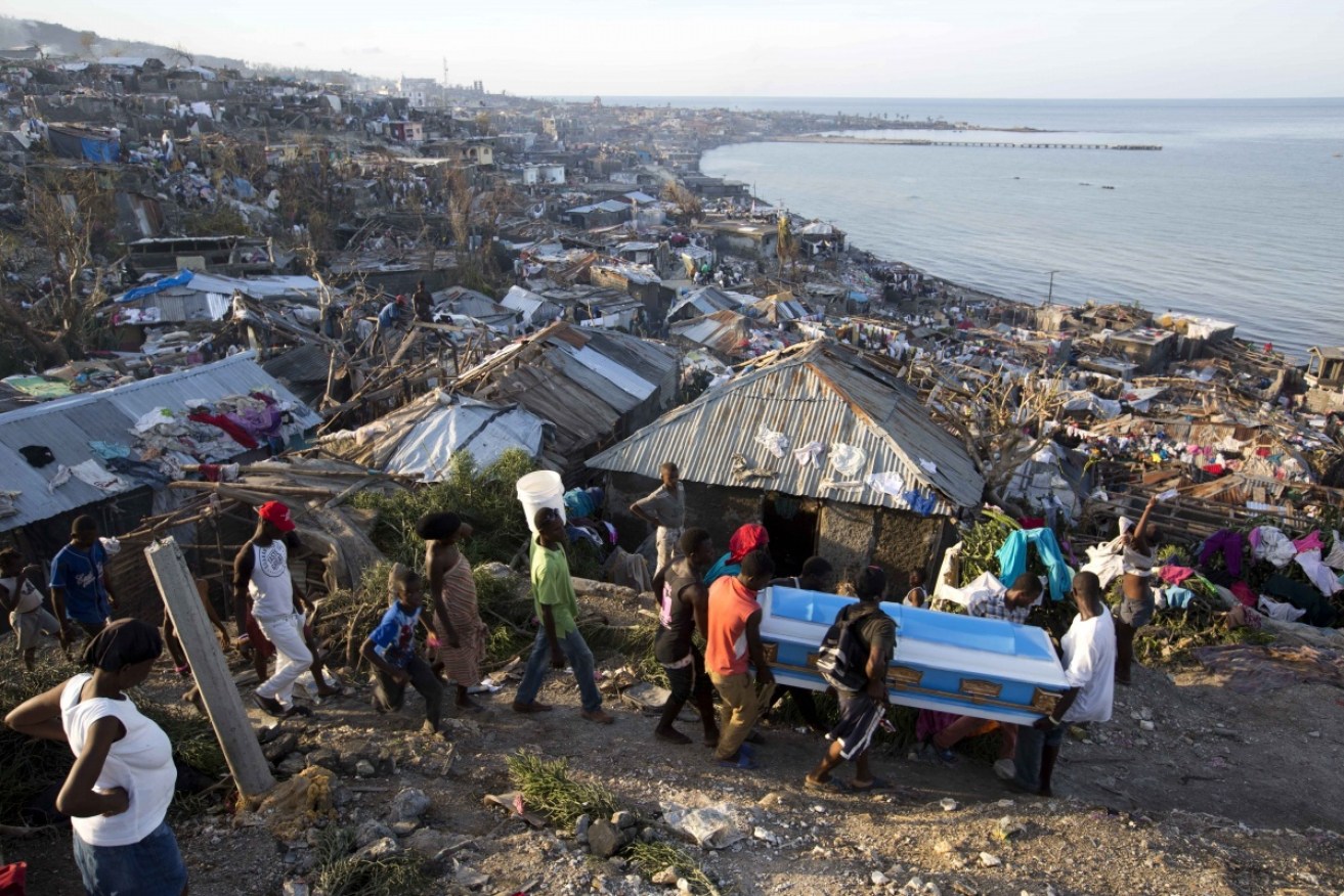 Residents carry a coffin containing the remains of a pregnant woman, a victim of Hurricane Matthew, in Jeremie, Haiti.