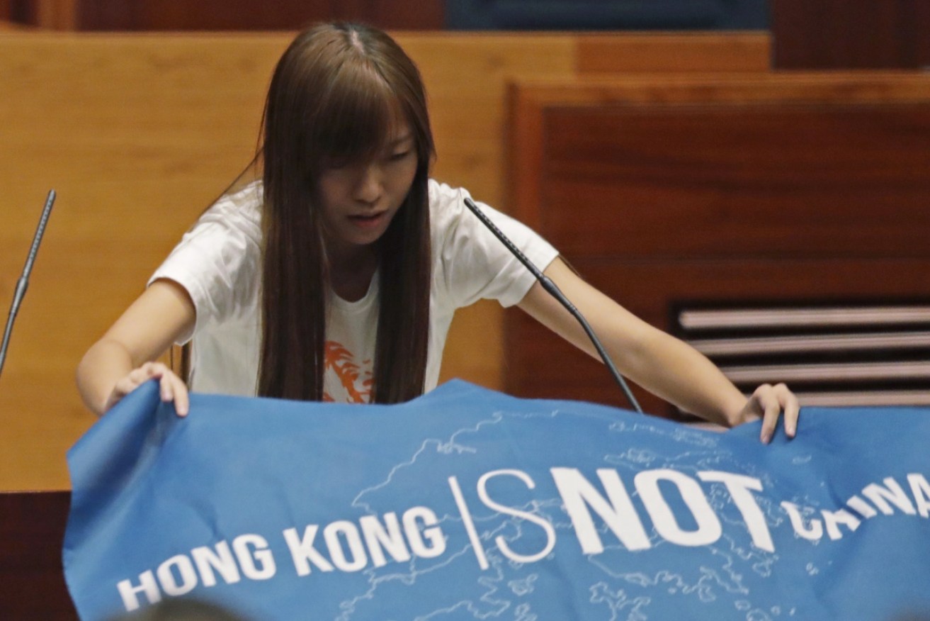 Yau Wai–ching displays a protest banner as she takes her oath.