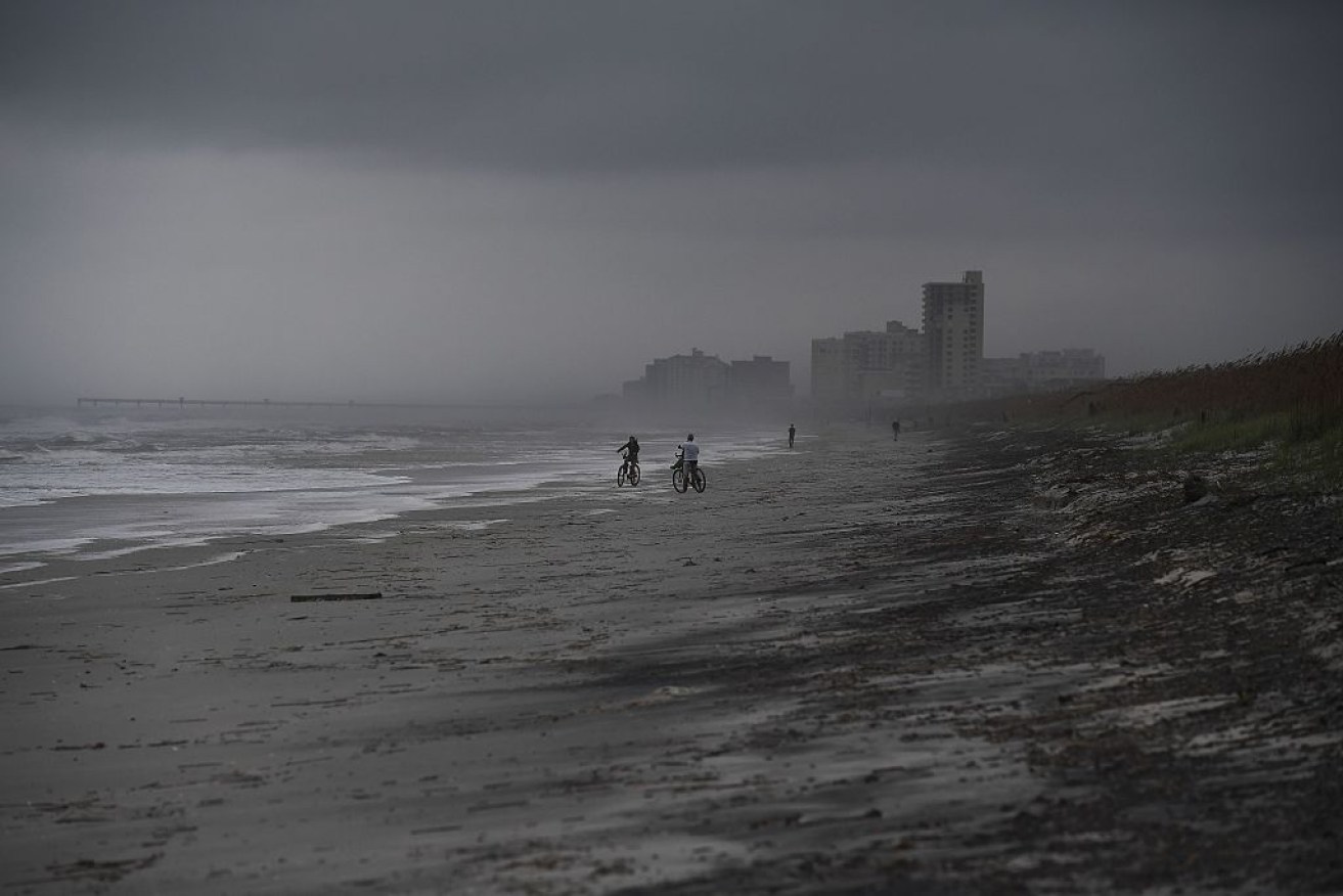 People bike on the beach ahead of Hurricane Matthew in Atlantic Beach, Florida. 
