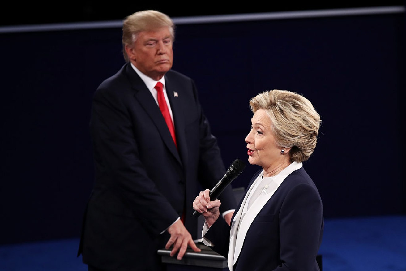 Hillary Clinton (R) speaks as Republican presidential nominee Donald Trump looks on during the town hall debate at Washington University.