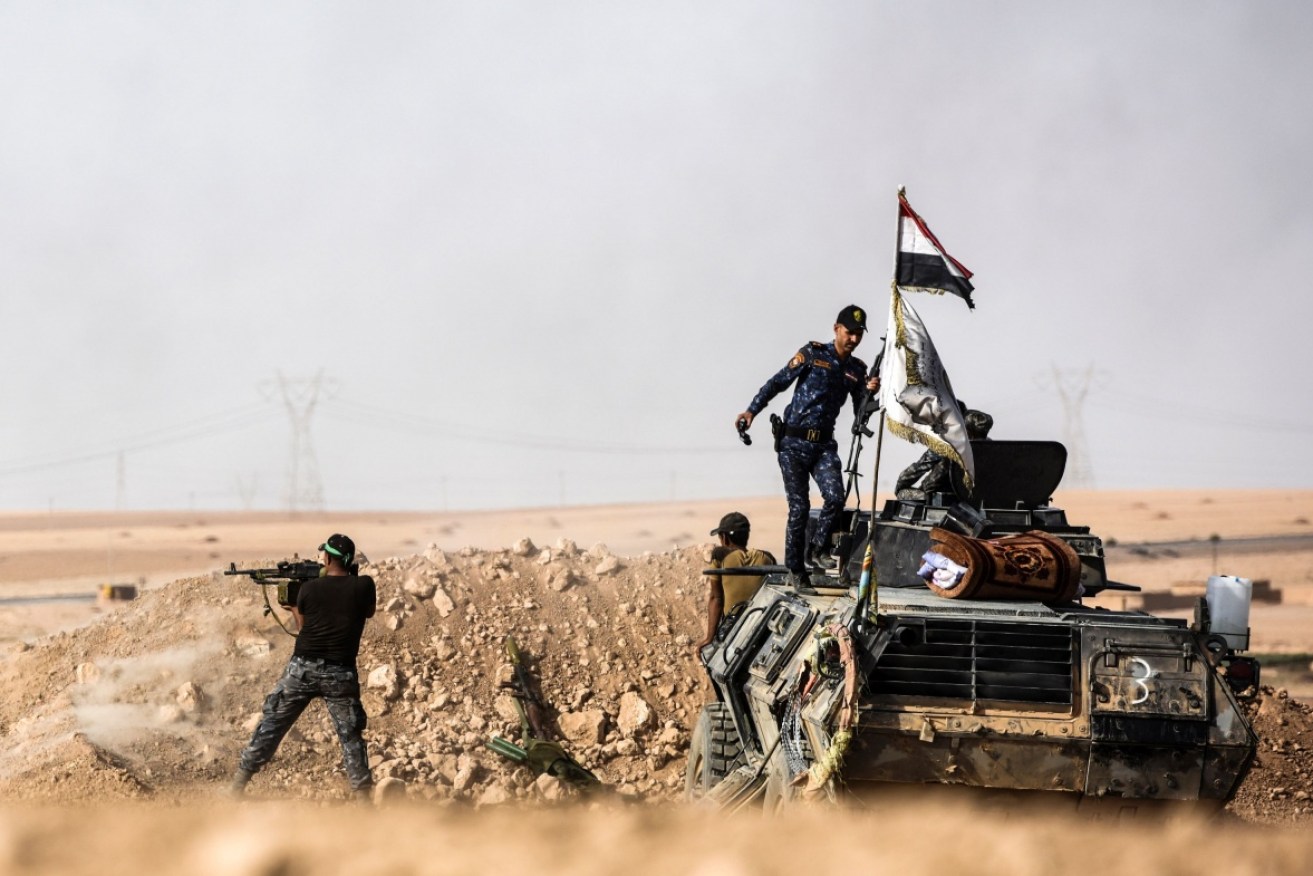 Members of Iraqi pro-government forces hold a position on the frontline, about 30 kilometres south of Mosul.

