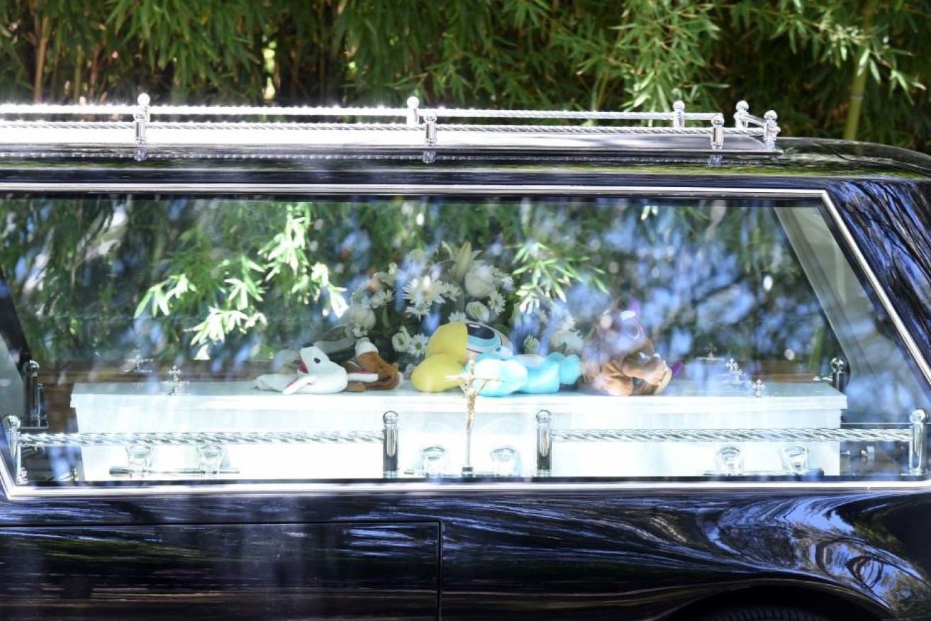 A hearse carrying coffins departs the Holy Name Church following the funeral for the Lutz-Manrique family. 
