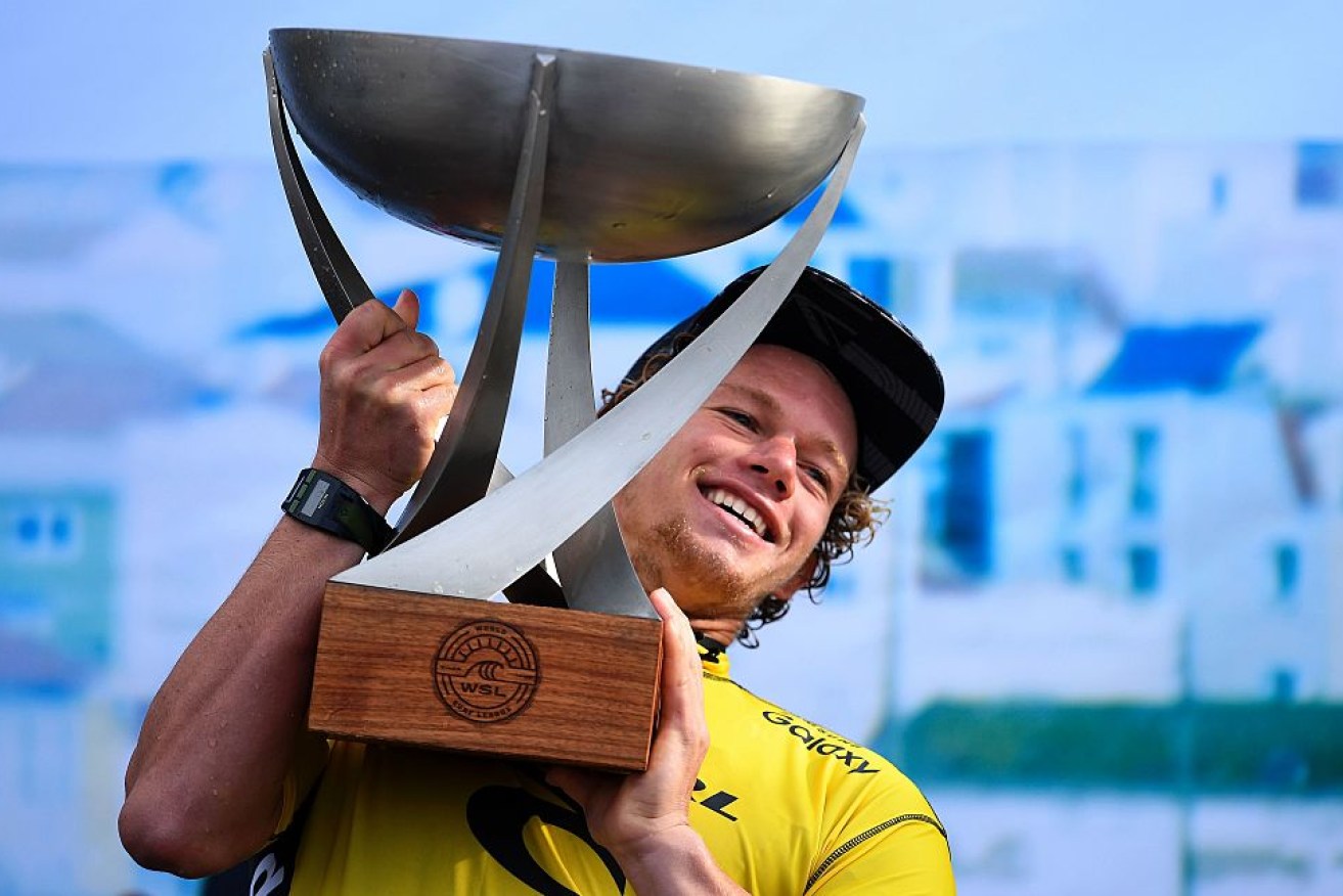 Hawaiian surfer John John Florence raises the the trophy after securing the World Surf League world title.