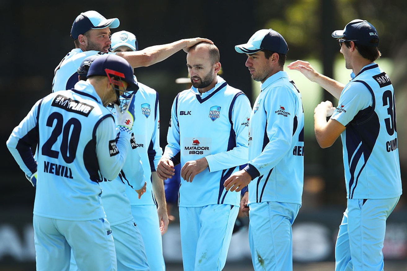 Nathan Lyon celebrates with teammates after claiming a wicket in the final against Queensland.