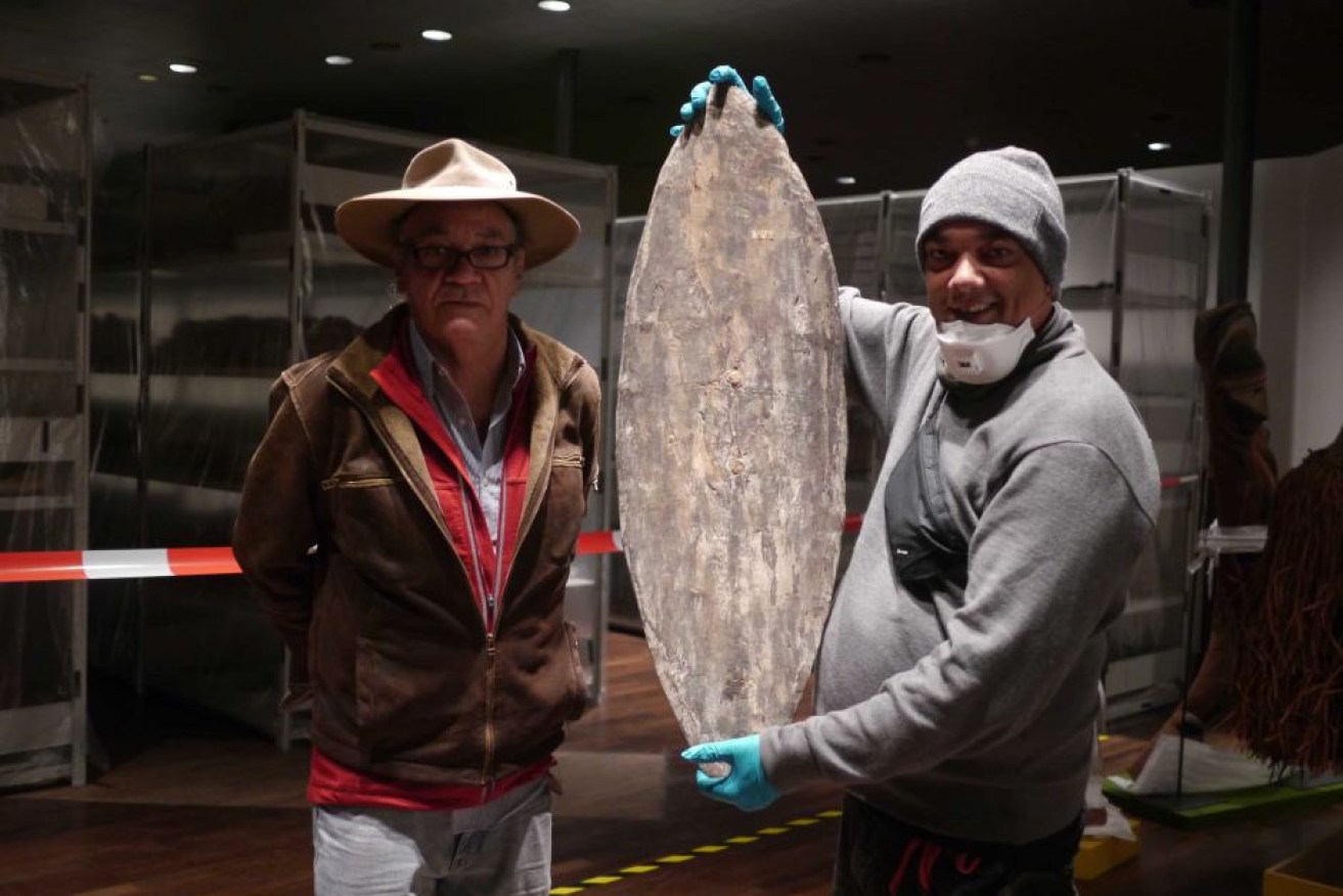 Rodney Kelly and Vincent Forrester stand with the shield found in a Berlin museum.