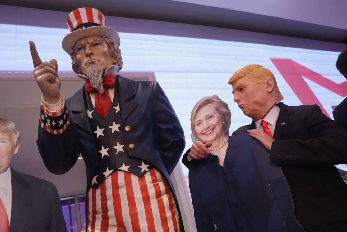 A guest dressed as Donald Trump clowns with a cardboard effigy of Hillary Clinton at a US election party.
