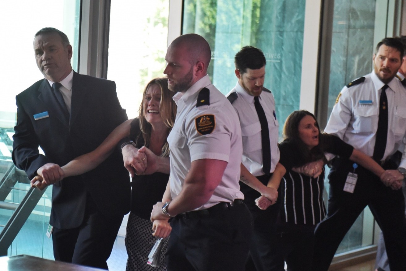Protestors are forcibly removed from the House of Representatives public gallery by security. 