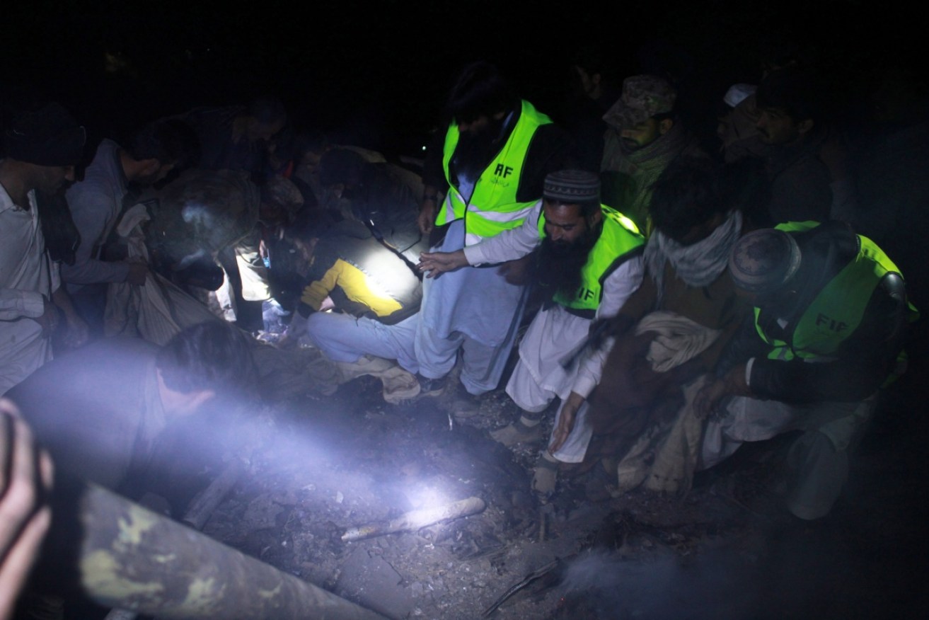 Rescue workers search for bodies from the downed Pakistan International Airlines ATR–42 turboprop plane, flight PK661.