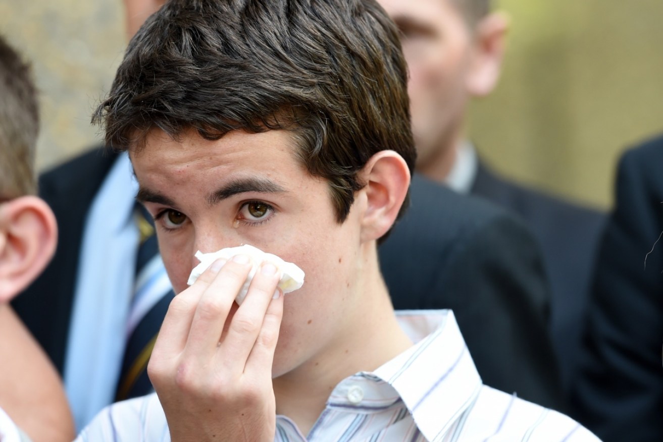  Cain, the son of NSW police officer Bryson Anderson, wipes his eyes as he leaves NSW Court of Criminal Appeal in Sydney on Monday, 