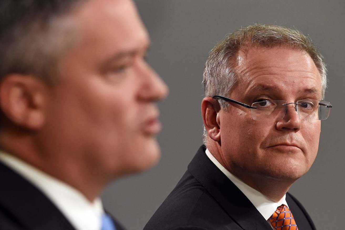 Australia's Treasurer Scott Morrison (R) listens to Minister for Finance Mathias Cormann (L) during a press conference.