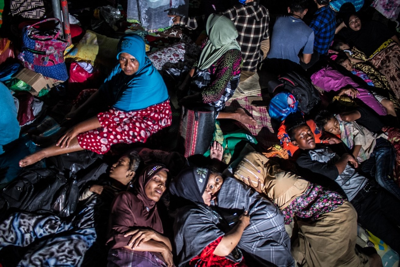Indonesian women and children displaced by an earthquake rest under a tent in Pidie Jaya, Aceh province.