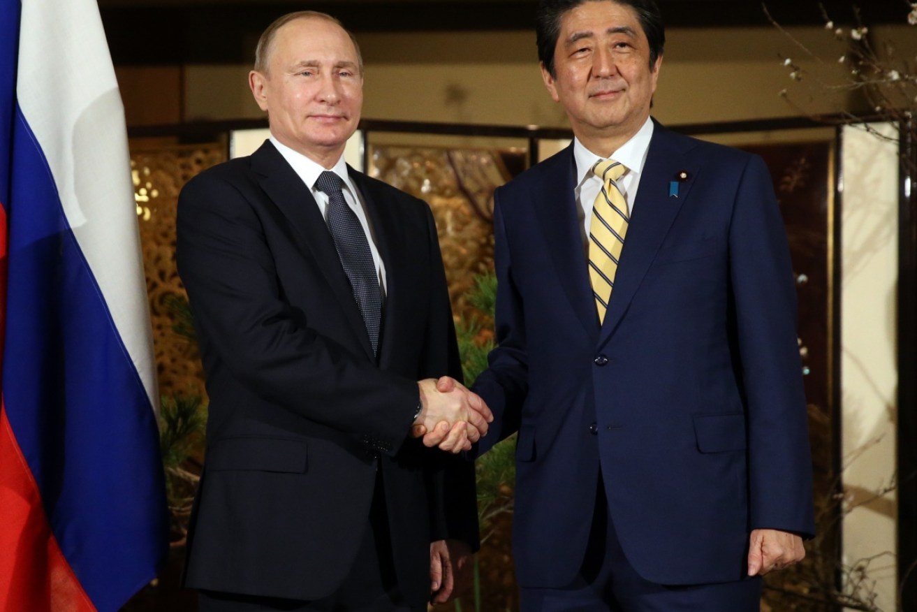 Shinzo Abe and Vladimir Putin shake hands at the official reception in Nagato.