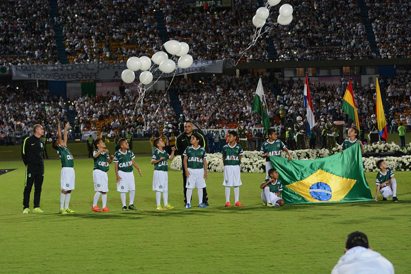 Children unveil a Brazilian flag in homage to the fallen football team.