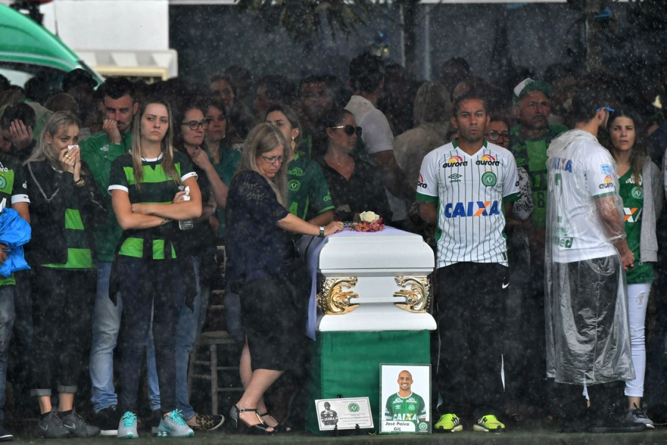 The family of Chapecoense midfielder Gil surround his coffin.