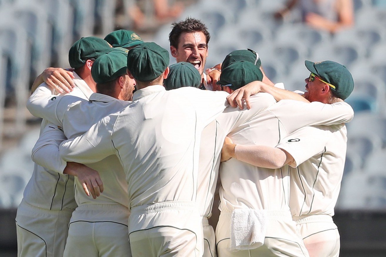 Mitchell Starc is swamped by his teammates after Australia won the Boxing Day Test.
