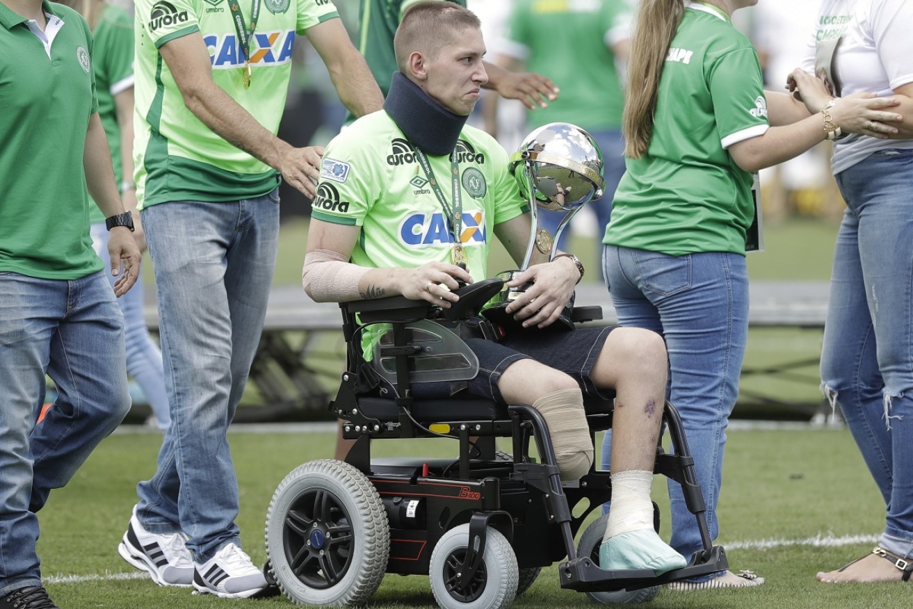 Chapecoense goalkeeper Follmann, one of the three players who survived last year's air crash, carries the Sudamericana trophy.