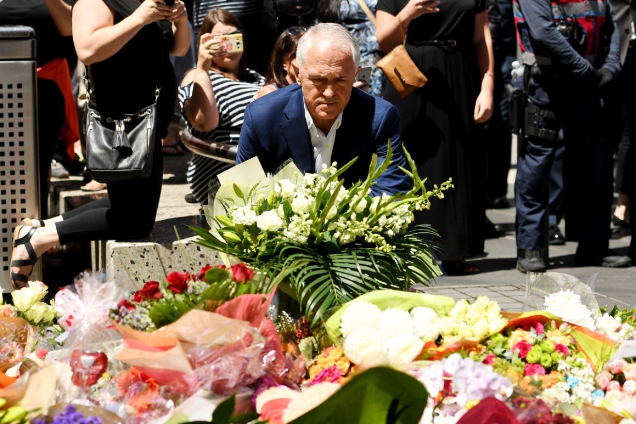 Prime minister Malcolm Turnbull has a reflective moment while placing flowers in the Bourke Street mall on Sunday.