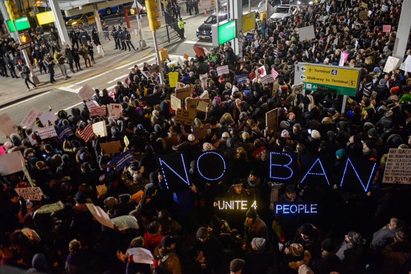 Protestors rally at New York's John F. Kennedy airport against the ban.