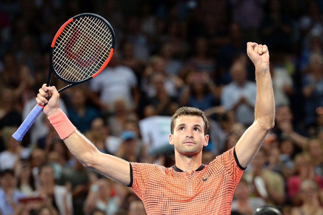 Grigor Dimitrov raises his arms in triumph after winning the title in Brisbane.