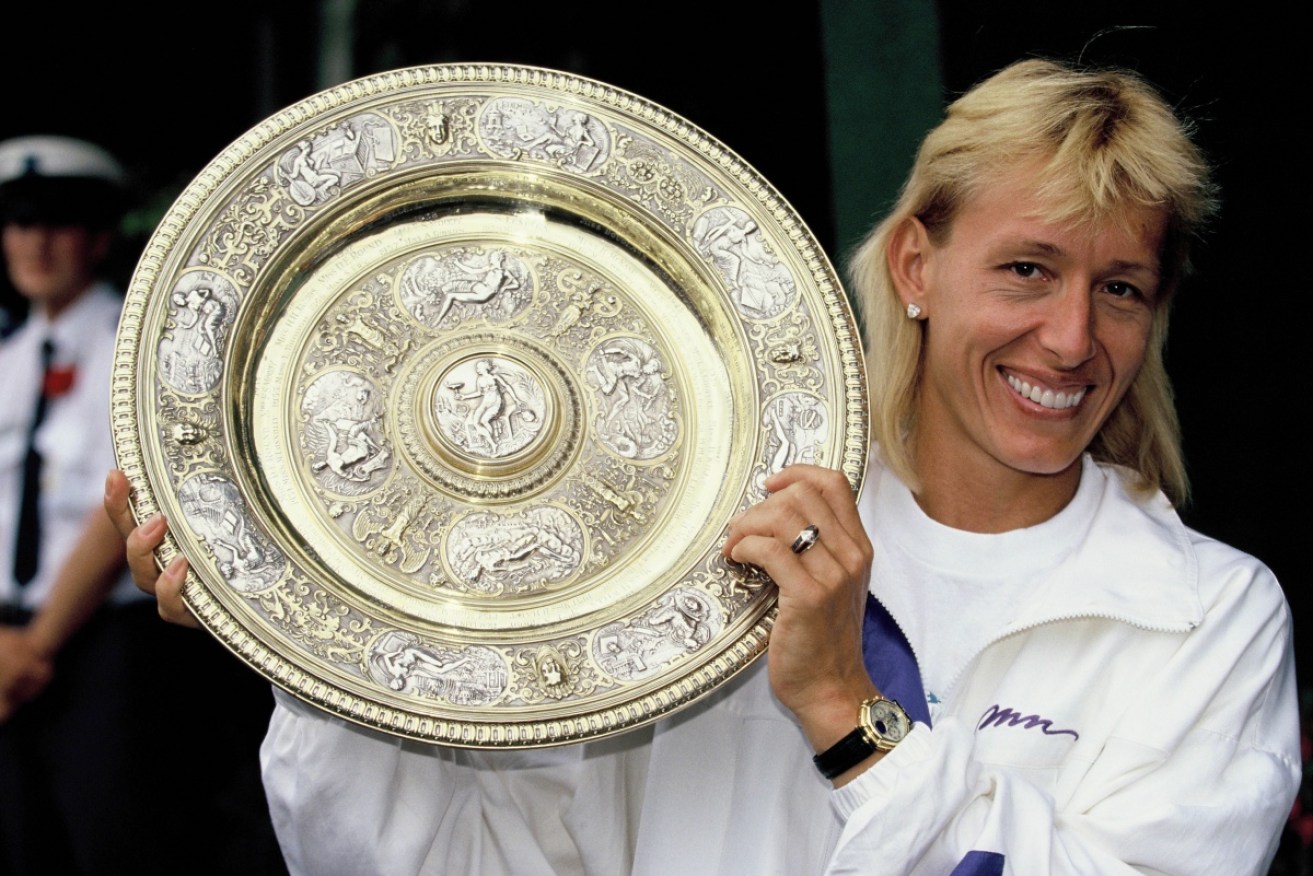 Martina Navratilova holds aloft the 1990 Wimbledon trophy.