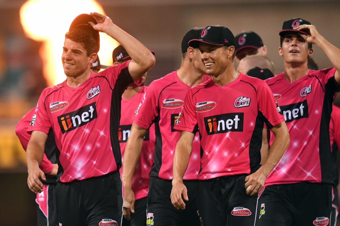 Sydney Sixers captain Moises Henriques leads players from the field after winning the semi-final against the Heat.